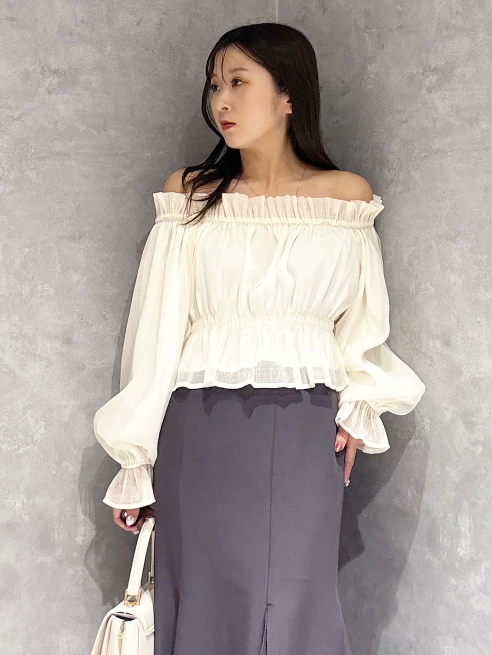 ホワイト系のハンドバッグ、ホワイト系のパンプス、ホワイト系のシャツ/ブラウスを着用したレディースの春コーディネートの6枚目の写真