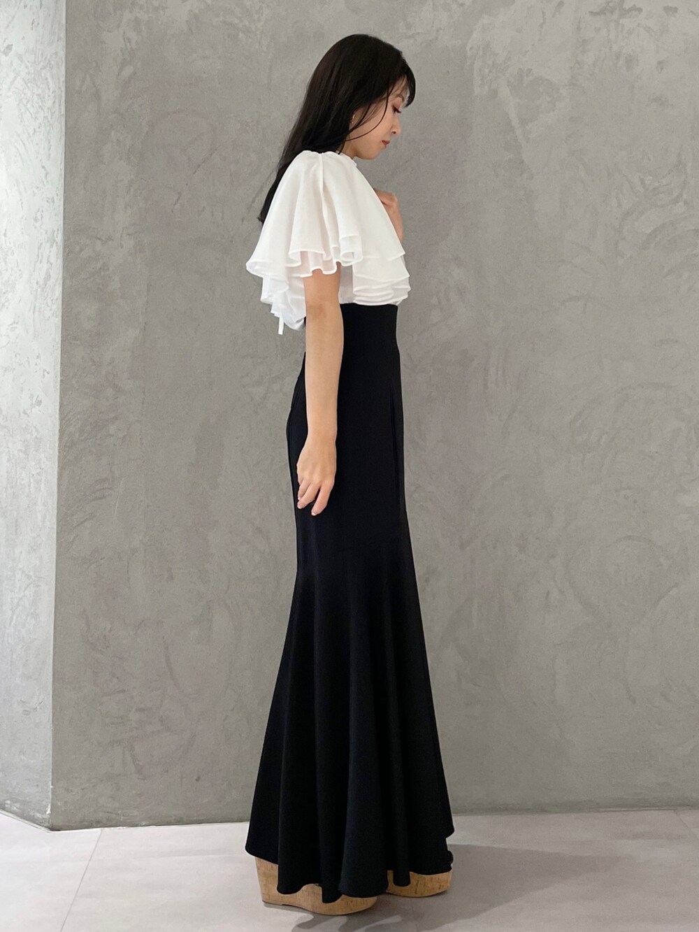 ブラック系のスカート、ブラック系のサンダル、ホワイト系のシャツ/ブラウスを着用したレディースの春コーディネートの5枚目の写真