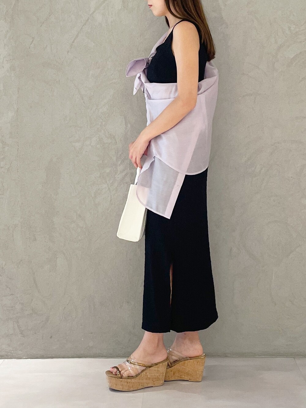 ピンク系のトートバッグ、ブラウン系のサンダル、ブラック系のワンピースを着用したレディースの夏コーディネートの4枚目の写真