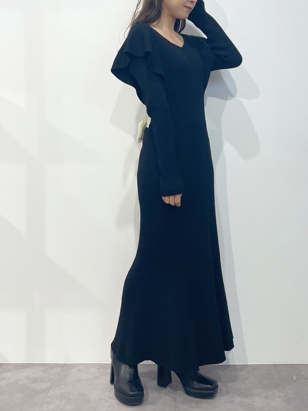 ブラック系のワンピース、ブラック系のブーツを着用したレディースの冬コーディネートの2枚目の写真