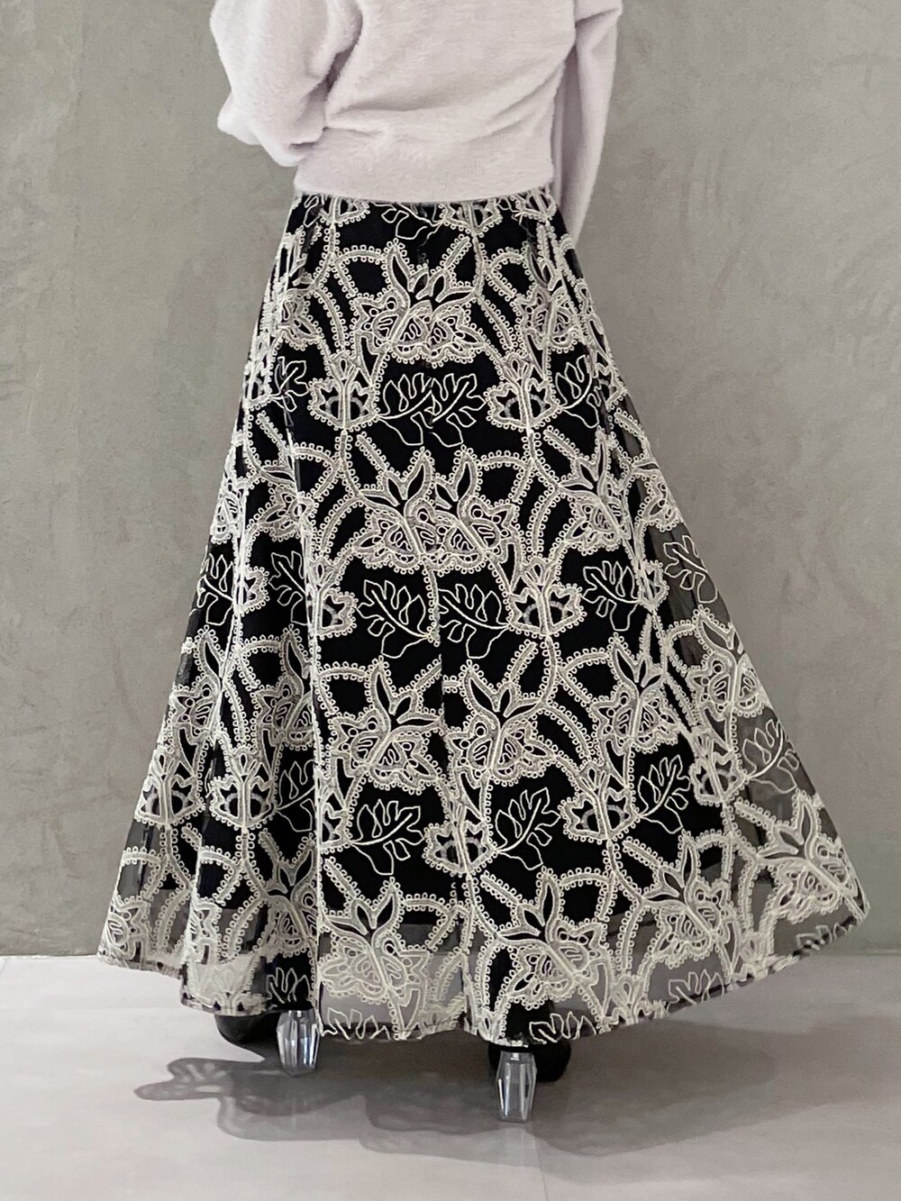 ブラック系のスカート、グレー系のカーディガン/ボレロ、ブラック系のブーツを着用したレディースの冬コーディネートの7枚目の写真