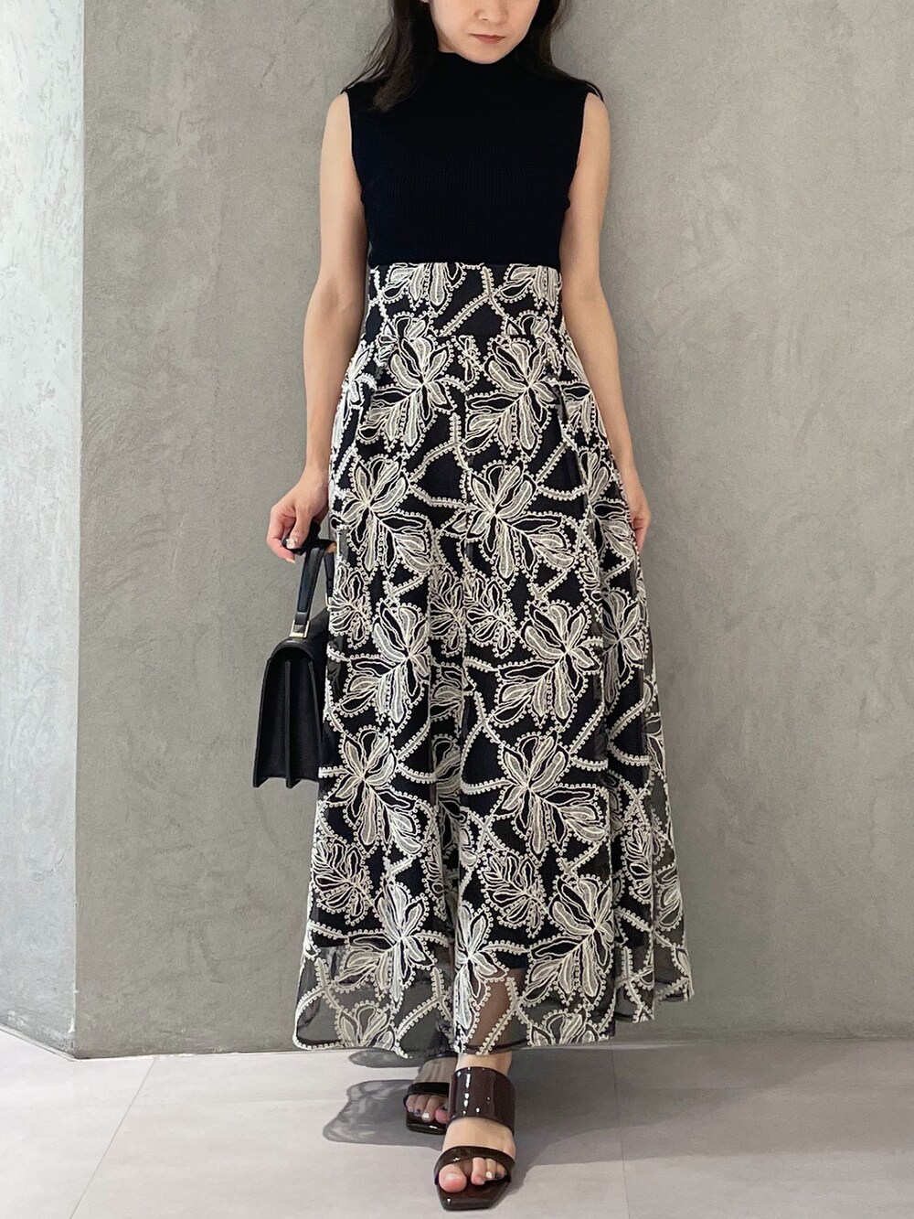 ブラウン系のサンダル、ブラック系のハンドバッグ、ブラック系のニット/セーターを着用したレディースの夏コーディネートの4枚目の写真