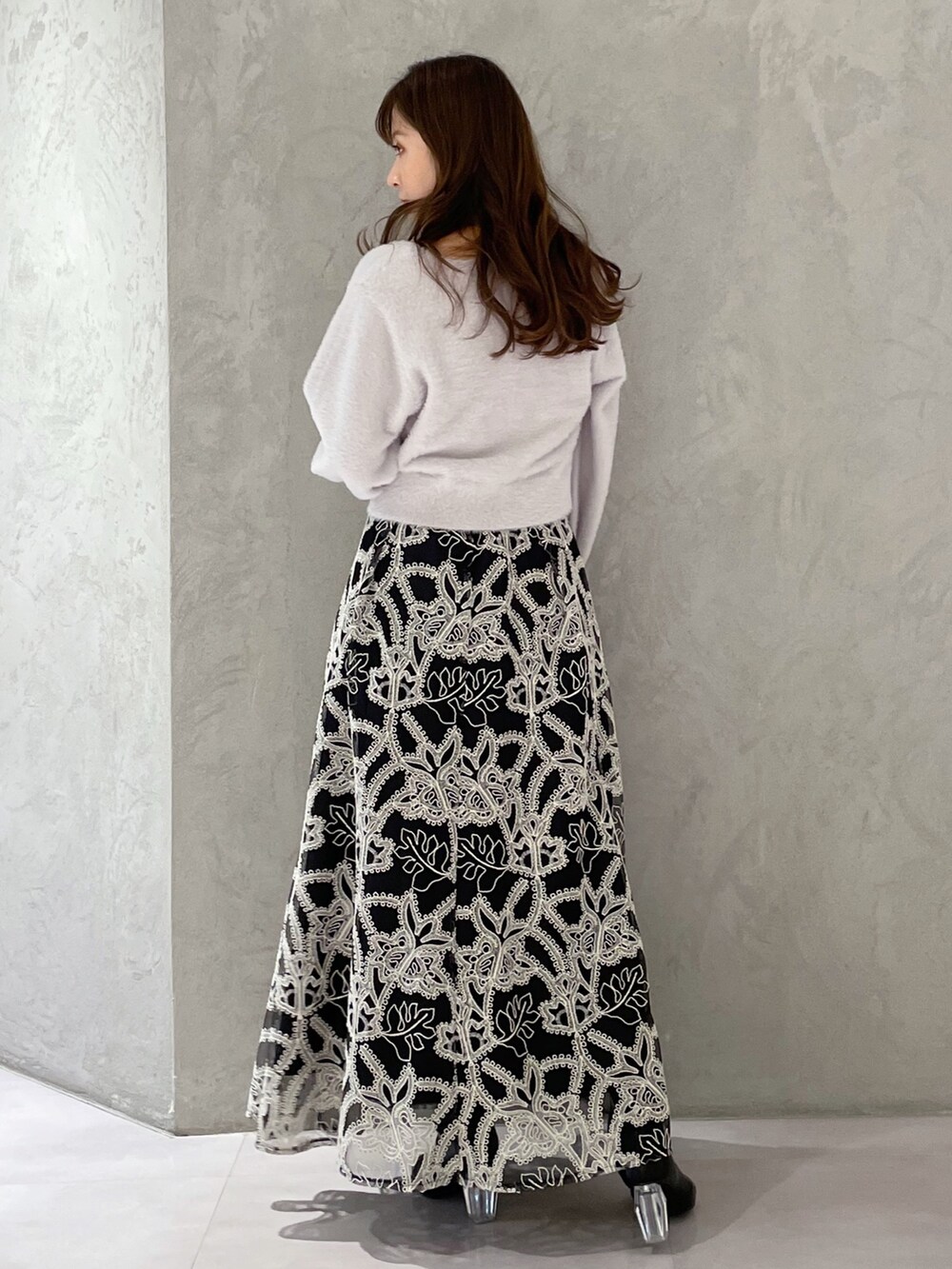 ブラック系のスカート、グレー系のカーディガン/ボレロ、ブラック系のブーツを着用したレディースの冬コーディネートの5枚目の写真