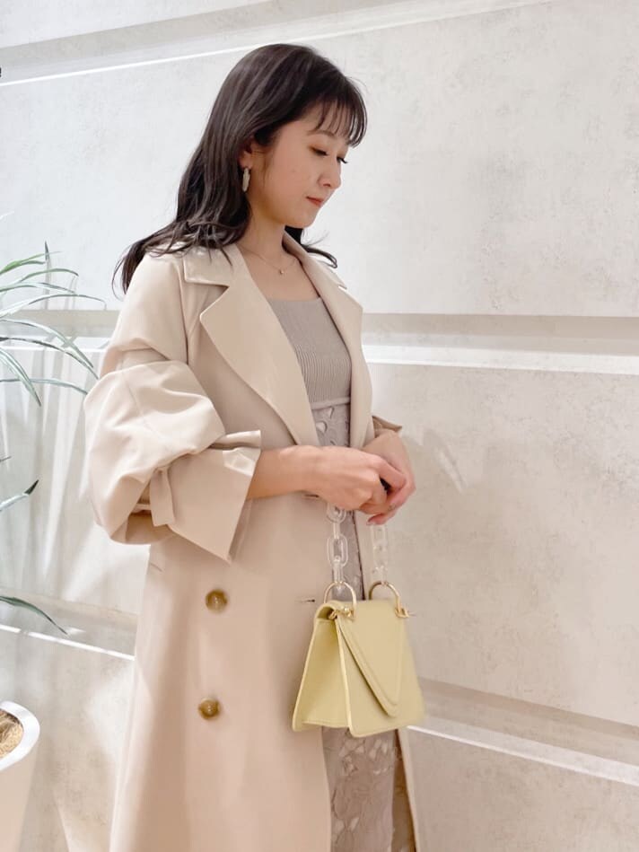 ベージュ系のその他シューズ、ベージュ系のトレンチコート、イエロー系のショルダーバッグを着用したレディースの冬コーディネートの6枚目の写真