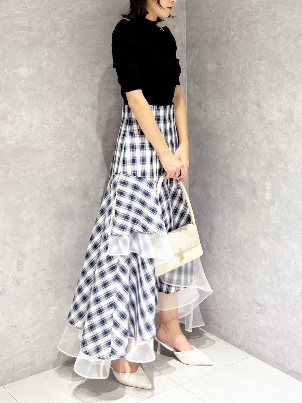 その他のスカート、ホワイト系のパンプス、ブラック系のニット/セーターを着用したレディースの春コーディネートの2枚目の写真