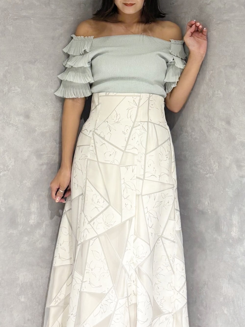 ホワイト系のスカート、グリーン系のニット/セーター、ブラウン系のサンダルを着用したレディースの夏コーディネートの6枚目の写真