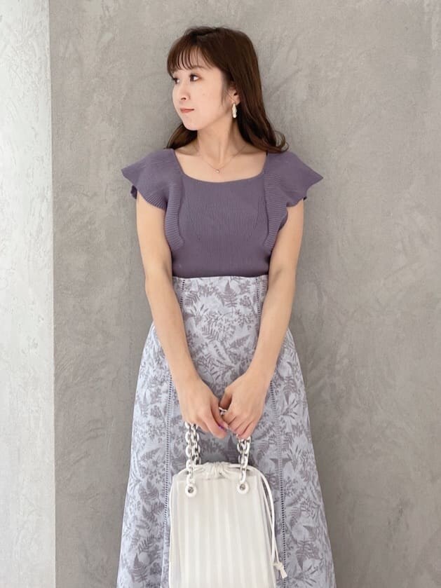 ホワイト系のハンドバッグ、グリーン系のサンダル、ブルー系のニット/セーターを着用したレディースの春コーディネートの2枚目の写真