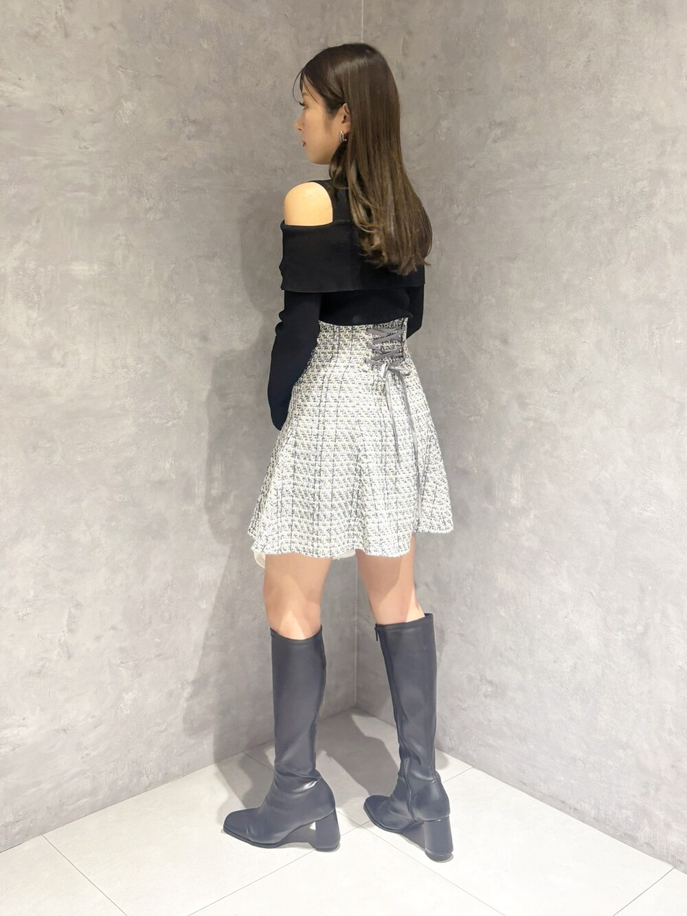 ブラック系のブーツ、ホワイト系のハンドバッグ、ブラック系のニット/セーターを着用したレディースの冬コーディネートの7枚目の写真