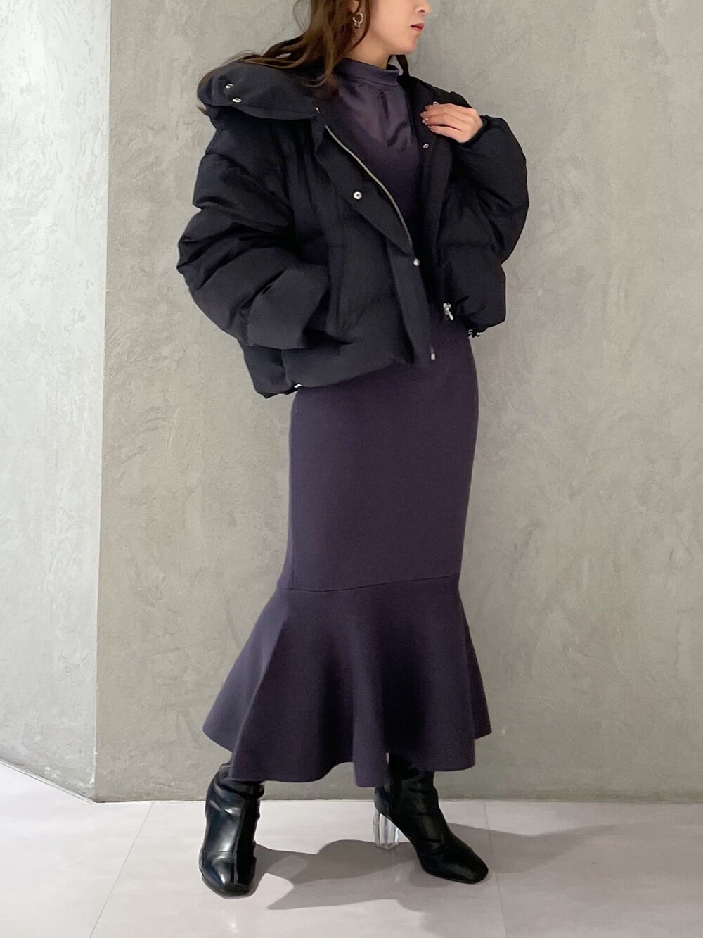 ブラック系のダウンジャケット/コート、ブルー系のワンピース、ブラック系のブーツを着用したレディースの冬コーディネートの3枚目の写真