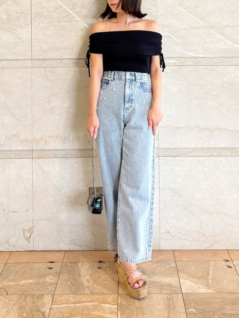 ブラック系のボディバッグ/ウエストポーチ、ブラック系のニット/セーター、ブルー系のデニムパンツを着用したレディースの夏コーディネートの9枚目の写真