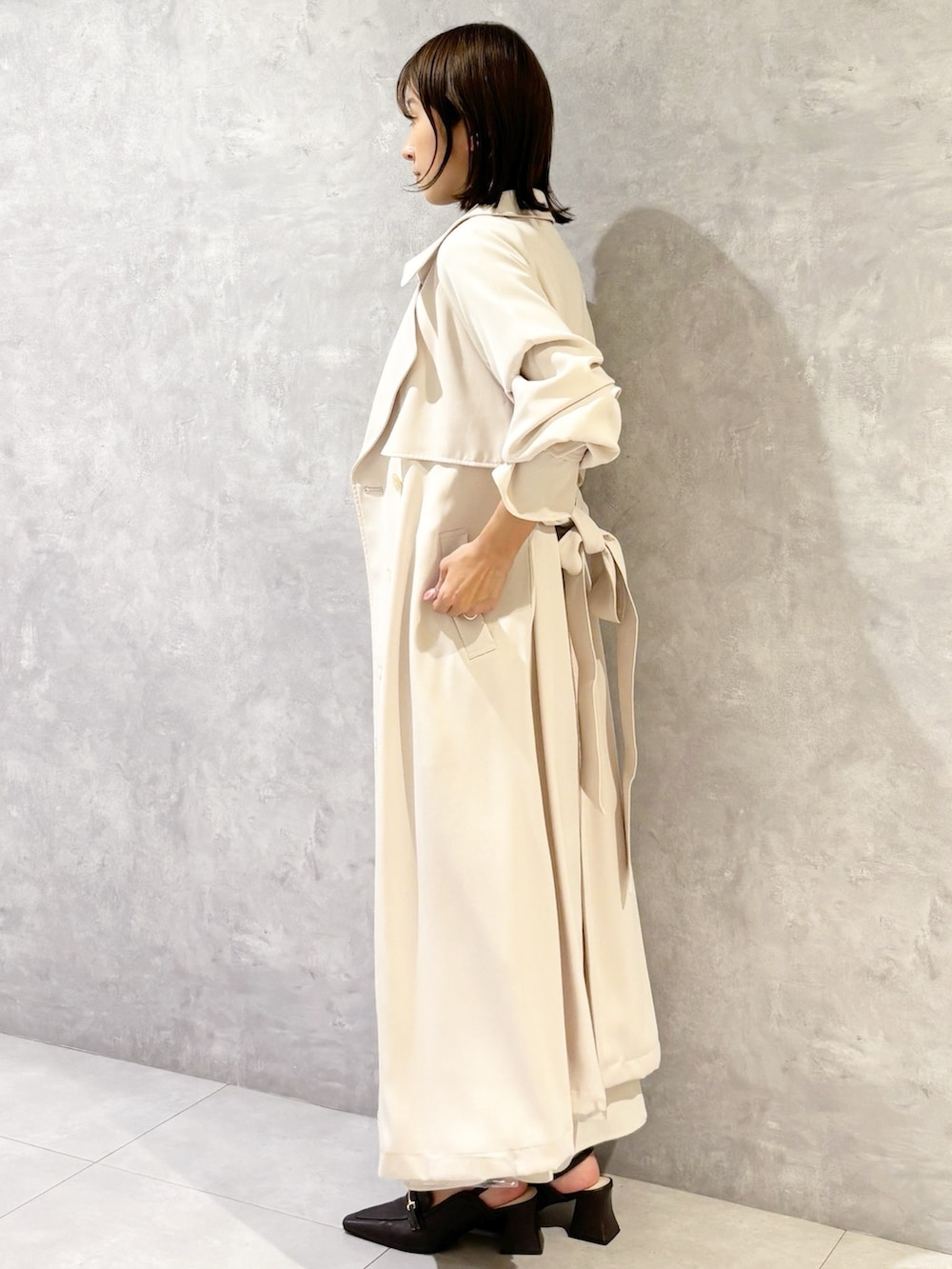 ホワイト系のスカート、ブラウン系のパンプス、ブラック系のニット/セーターを着用したレディースの春コーディネートの2枚目の写真