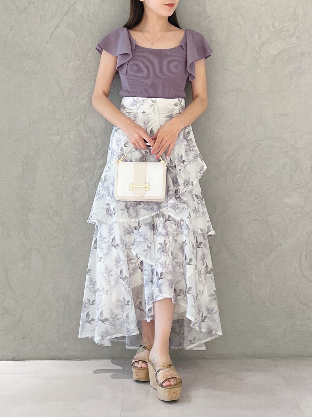 ホワイト系のハンドバッグ、パープル系のスカート、ブラウン系のサンダルを着用したレディースの春コーディネートの4枚目の写真