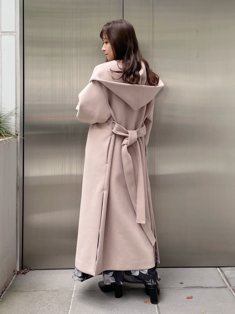 ブラック系のスカート、ブラック系のニット/セーター、ベージュ系のチェスターコートを着用したレディースの秋コーディネートの5枚目の写真