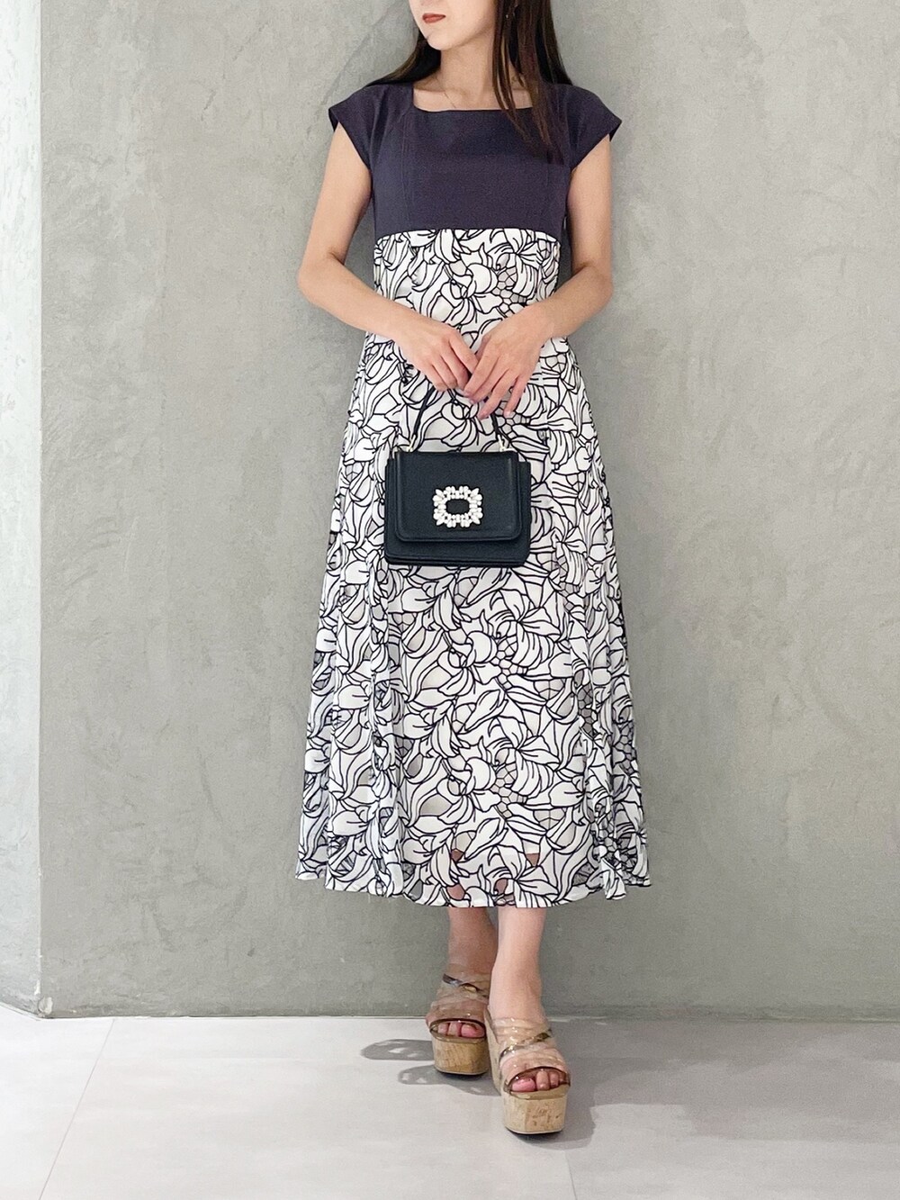 ブラック系のショルダーバッグ、ブラウン系のサンダル、ホワイト系のワンピースを着用したレディースの夏コーディネートの3枚目の写真