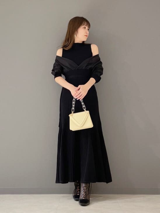 ブラック系のその他シューズ、ブラック系のワンピース、イエロー系のショルダーバッグを着用したレディースの冬コーディネートの6枚目の写真