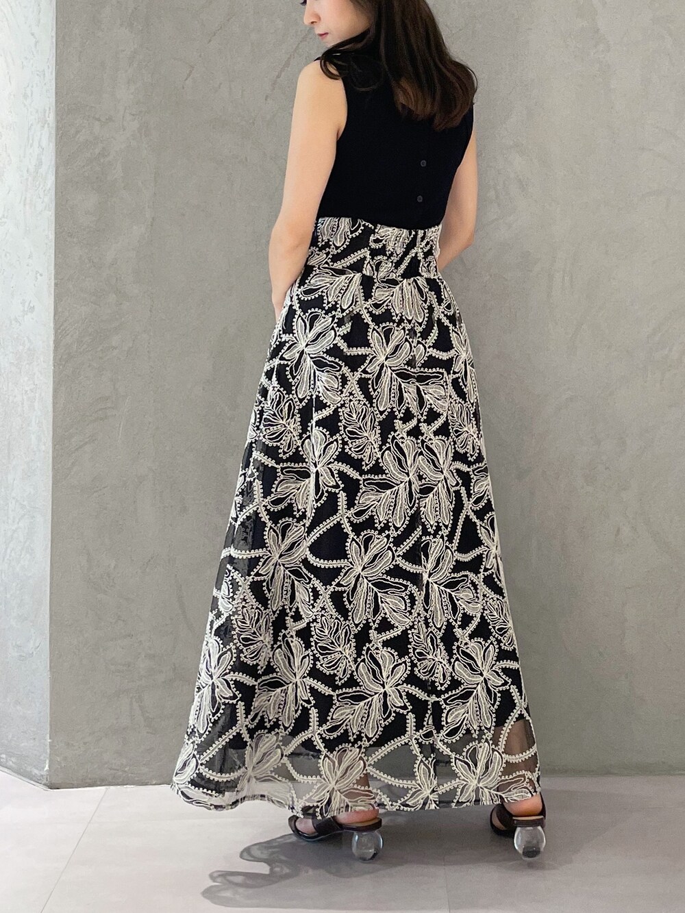 ブラウン系のサンダル、ブラック系のハンドバッグ、ブラック系のニット/セーターを着用したレディースの夏コーディネートの3枚目の写真