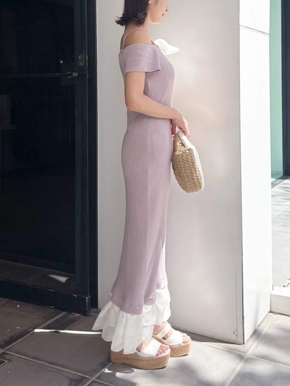 ピンク系のワンピース、ベージュ系のハンドバッグ、ホワイト系のサンダルを着用したレディースの夏コーディネートの6枚目の写真