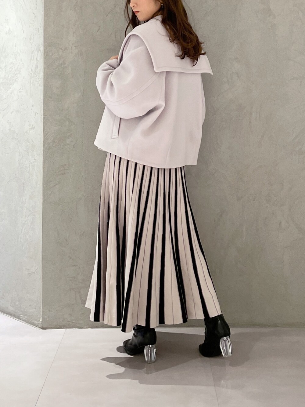 ブラック系のワンピース、グレー系のその他アウター、ブラック系のブーツを着用したレディースの冬コーディネートの7枚目の写真