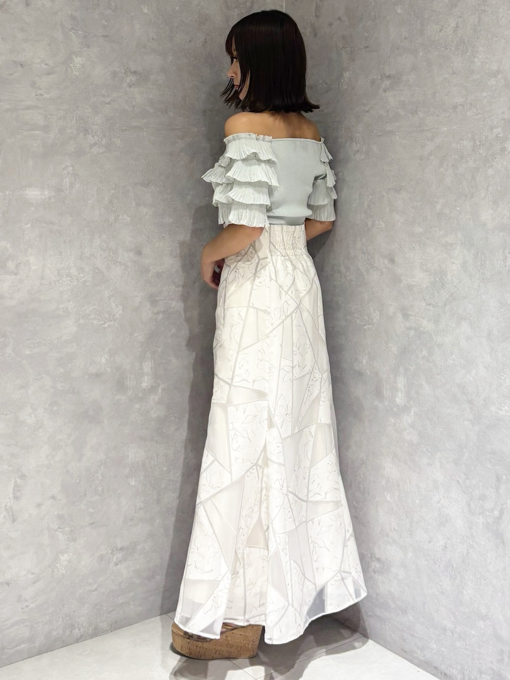 ホワイト系のスカート、グリーン系のニット/セーター、ブラウン系のサンダルを着用したレディースの夏コーディネートの4枚目の写真