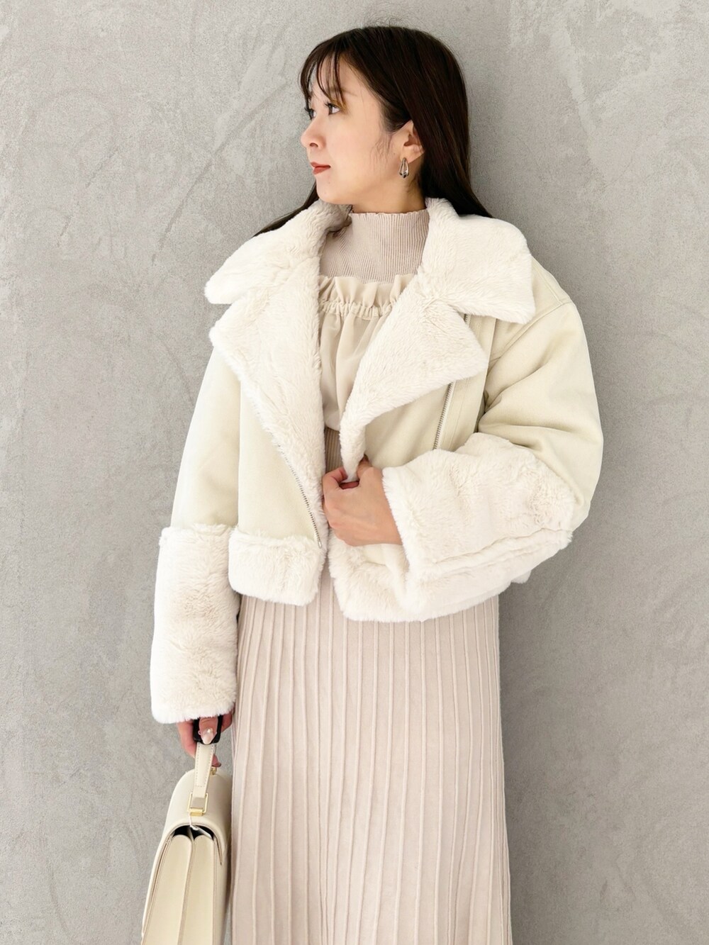 ホワイト系のワンピース、ブラック系のブーツ、ホワイト系のハンドバッグを着用したレディースの秋コーディネートの6枚目の写真