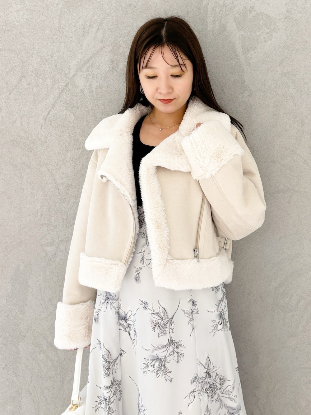 ブラック系のワンピース、ブラック系のブーツ、ホワイト系のハンドバッグを着用したレディースの秋コーディネートの3枚目の写真