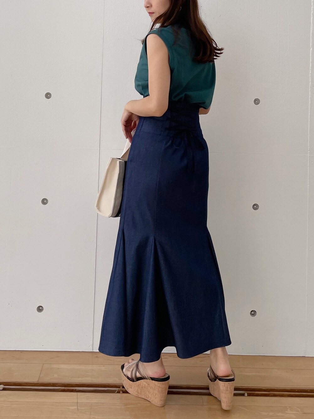 グレー系のハンドバッグ、ブラック系のサンダル、ブルー系のスカートを着用したレディースの春コーディネートの4枚目の写真