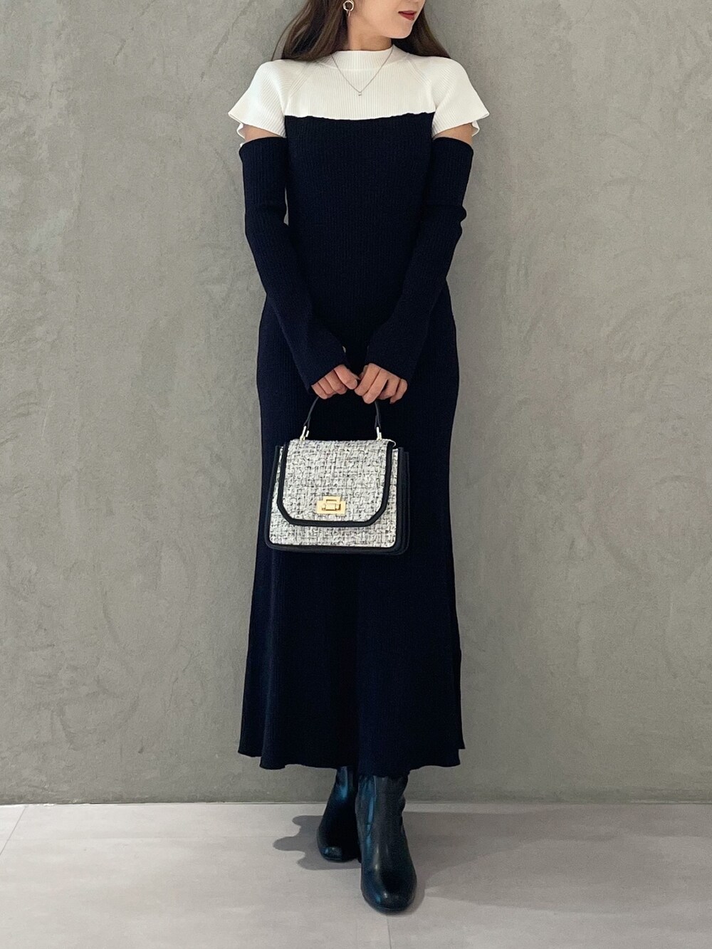 ブラック系のワンピース、ブラック系のショルダーバッグ、ブラック系のブーツを着用したレディースの秋コーディネートの6枚目の写真