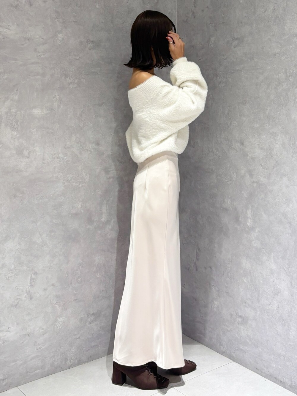 ピンク系のスカート、ホワイト系のニット/セーター、ブラウン系のブーツを着用したレディースの秋コーディネートの3枚目の写真