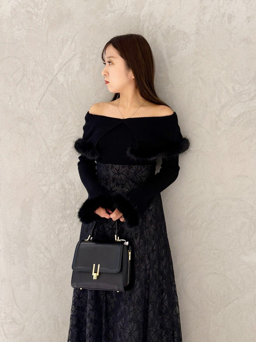 ブラック系のスカート、ブラック系のブーツ、ブラック系のショルダーバッグを着用したレディースの冬コーディネートの7枚目の写真