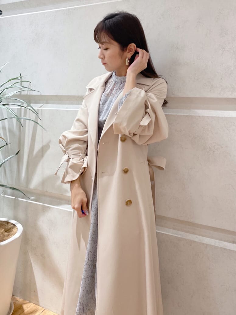 ベージュ系のその他シューズ、ベージュ系のトレンチコート、ブルー系のワンピースを着用したレディースの冬コーディネートの3枚目の写真