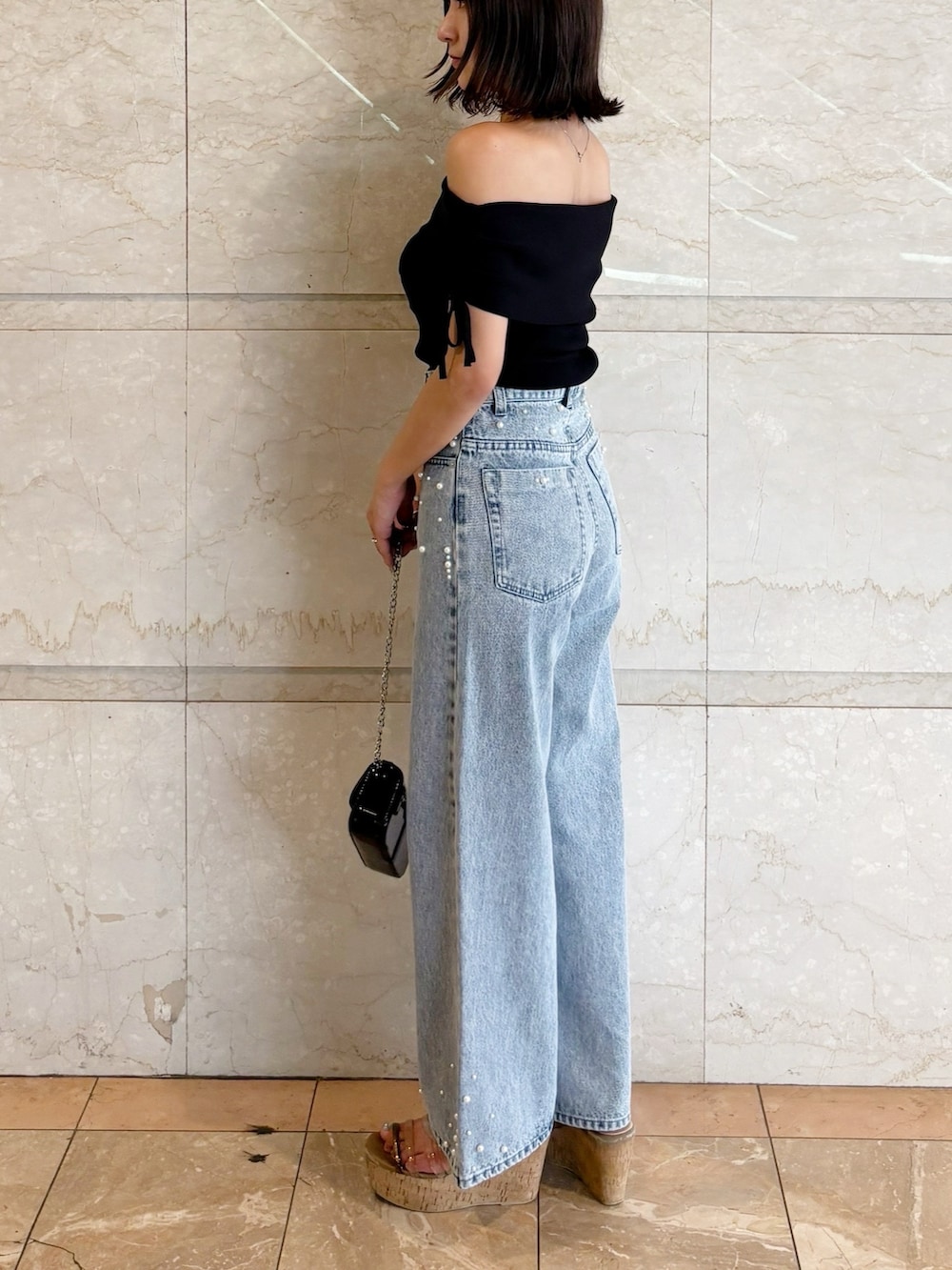 ブラック系のボディバッグ/ウエストポーチ、ブラック系のニット/セーター、ブルー系のデニムパンツを着用したレディースの夏コーディネートの8枚目の写真