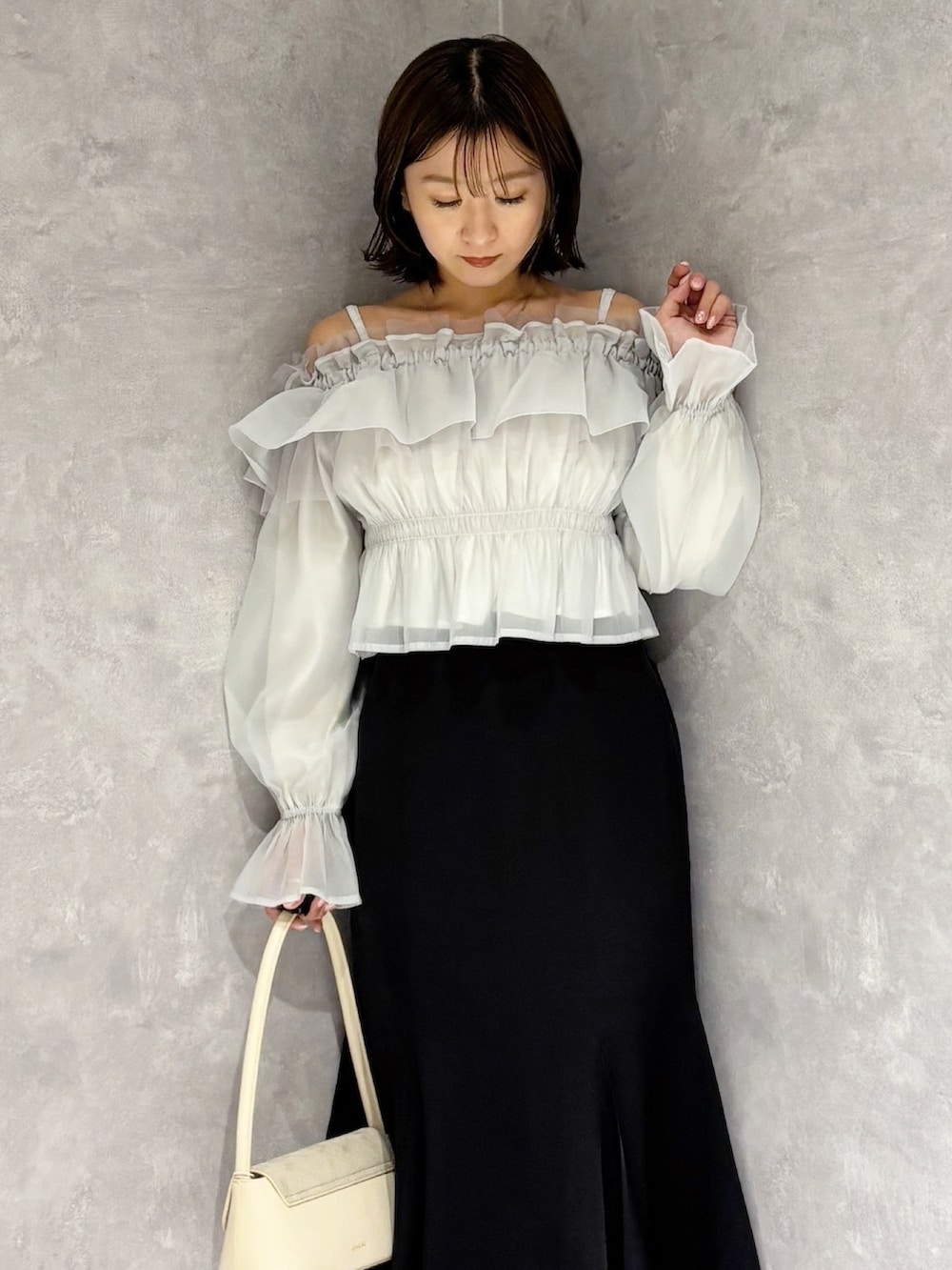 ブラック系のスカート、ホワイト系のパンプス、グリーン系のシャツ/ブラウスを着用したレディースの春コーディネートの5枚目の写真