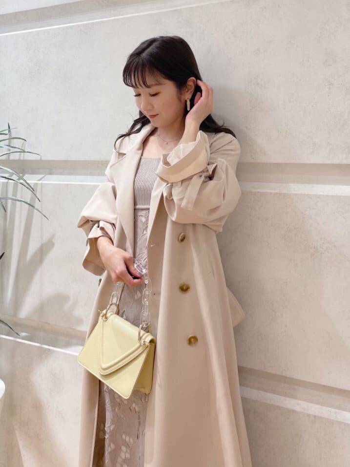 ベージュ系のその他シューズ、ベージュ系のトレンチコート、イエロー系のショルダーバッグを着用したレディースの冬コーディネートの2枚目の写真