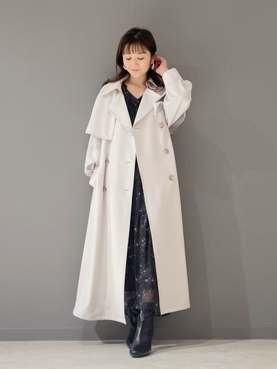 ブラック系のワンピース、ブラック系のその他シューズ、グレー系のトレンチコートを着用したレディースの冬コーディネートの6枚目の写真