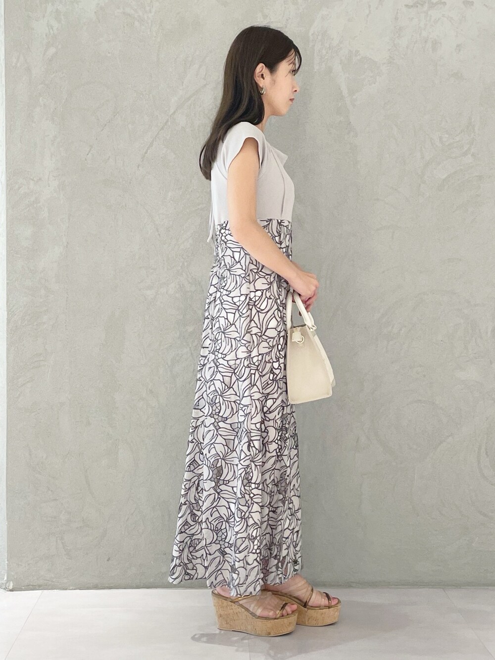 ホワイト系のショルダーバッグ、ブラウン系のサンダル、ベージュ系のワンピースを着用したレディースの春コーディネートの5枚目の写真