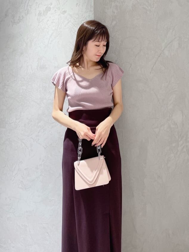 ピンク系のショルダーバッグ、ピンク系のニット/セーター、グリーン系のサンダルを着用したレディースの春コーディネートの2枚目の写真