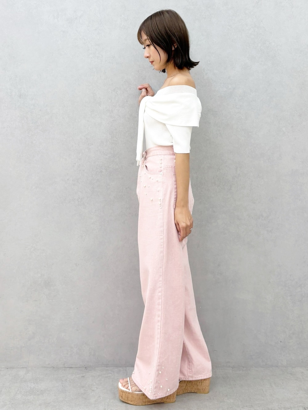 ピンク系のデニムパンツ、その他のサンダル、ホワイト系のニット/セーターを着用したレディースの春コーディネートの6枚目の写真