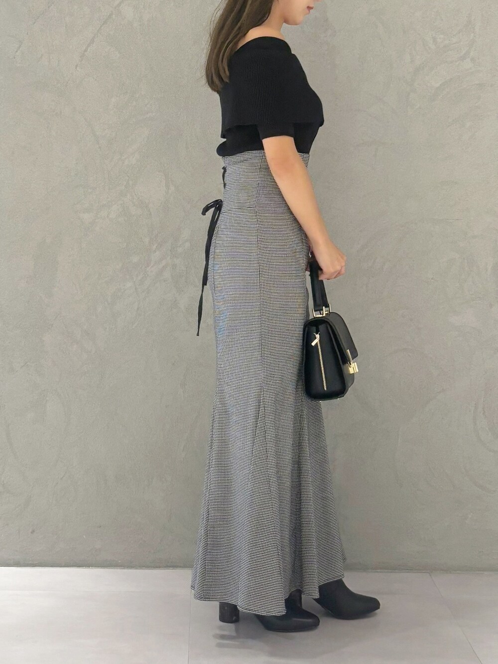 その他のスカート、ブラック系のブーツ、ブラック系のショルダーバッグを着用したレディースの秋コーディネートの6枚目の写真