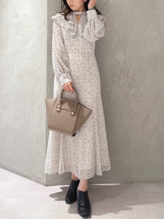 ブラウン系のハンドバッグ、ホワイト系のワンピース、ブラック系のサンダルを着用したレディースの夏コーディネートの7枚目の写真