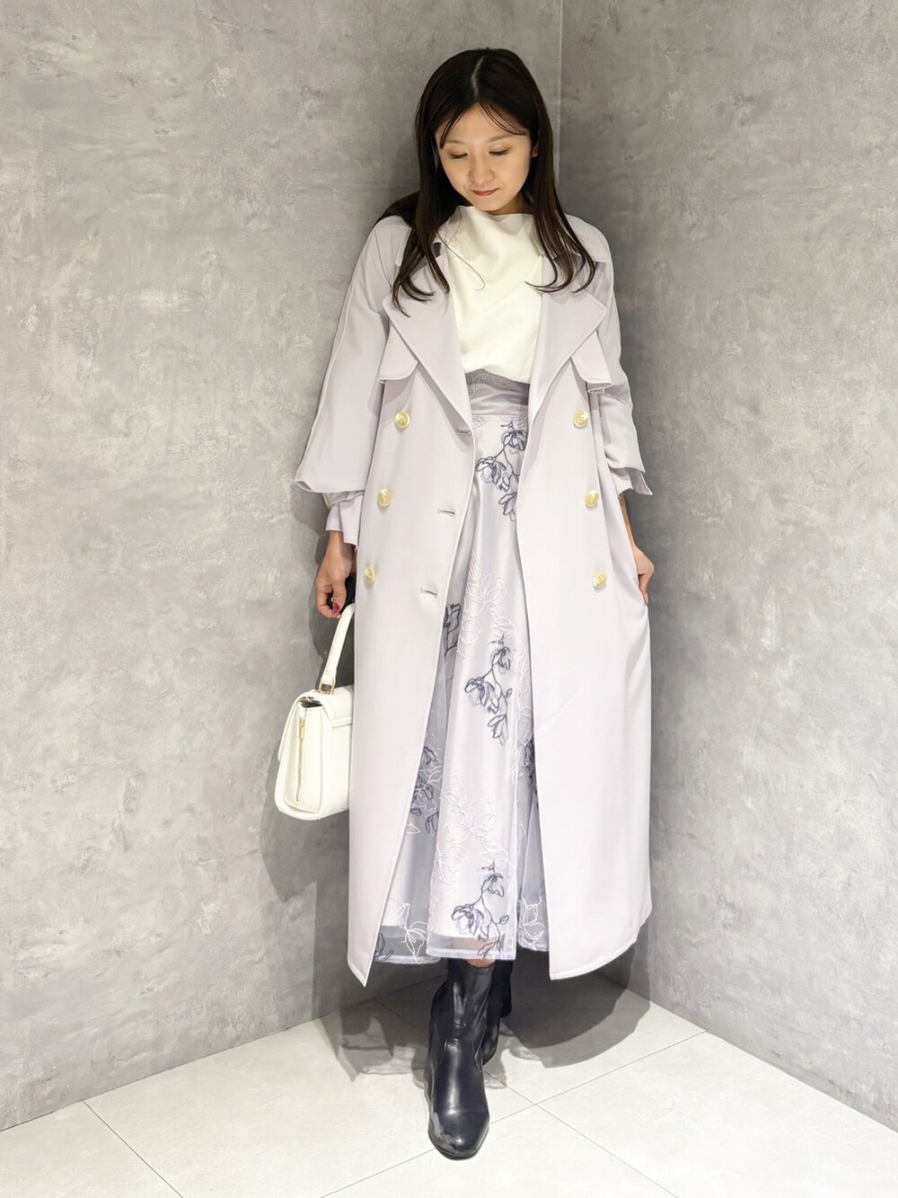 パープル系のスカート、ブラック系のブーツ、ホワイト系のハンドバッグを着用したレディースの冬コーディネートの7枚目の写真