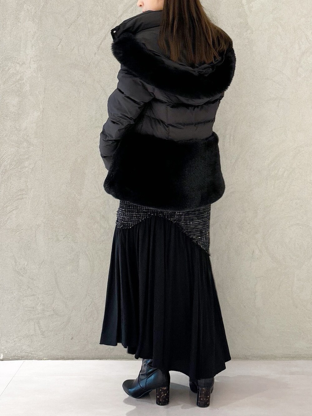 ブラック系のスカート、ブラック系のブーツ、ブラック系のショルダーバッグを着用したレディースの秋コーディネートの3枚目の写真