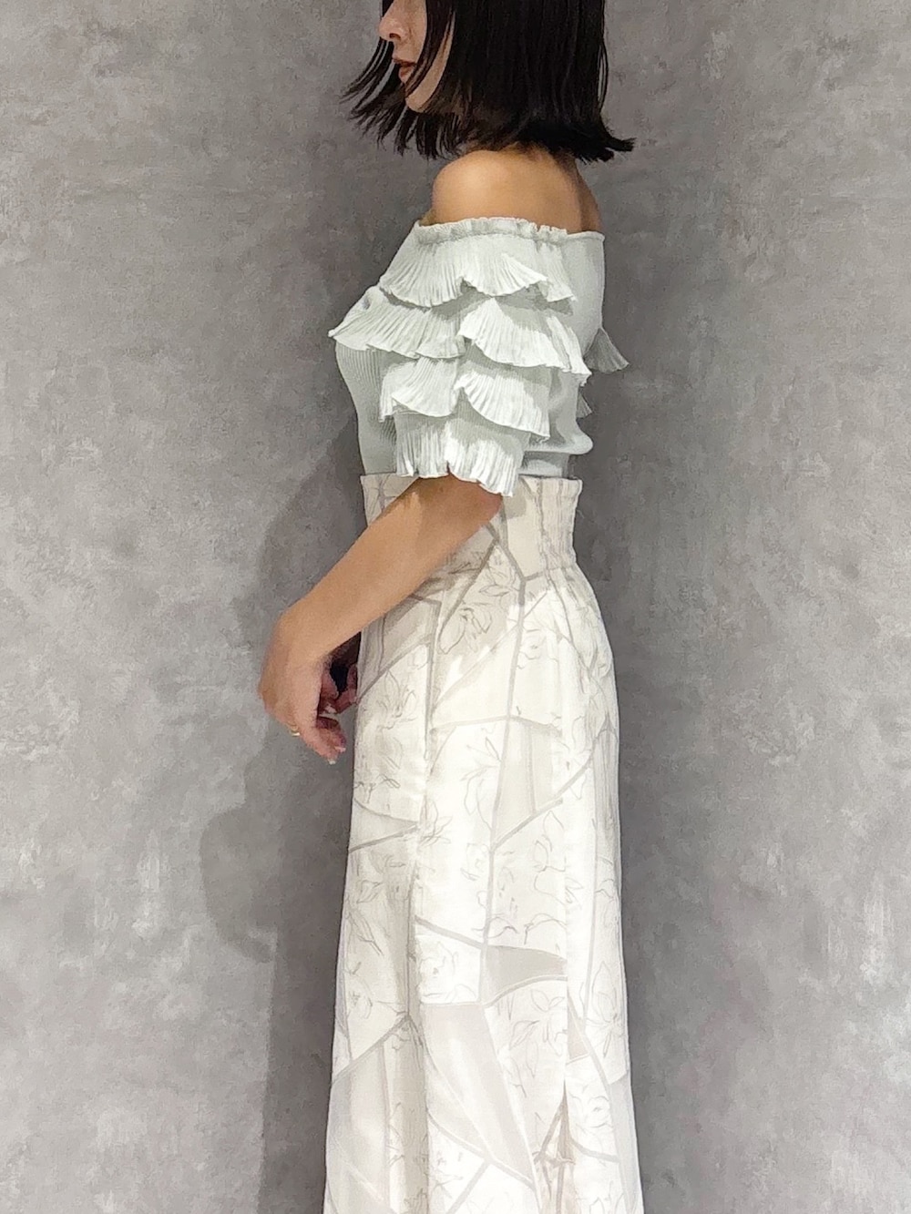 ホワイト系のスカート、グリーン系のニット/セーター、ブラウン系のサンダルを着用したレディースの夏コーディネートの3枚目の写真