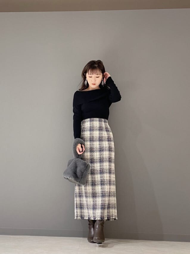 グリーン系のハンドバッグ、ブラック系のニット/セーター、ブルー系のスカートを着用したレディースの冬コーディネートの6枚目の写真