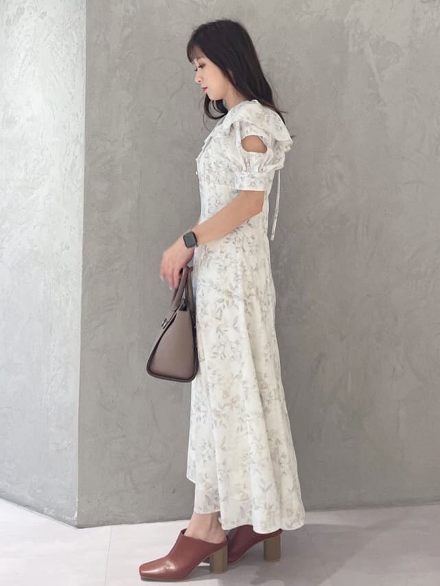 イエロー系のワンピース、ブラック系のサンダル、ブラウン系のハンドバッグを着用したレディースの夏コーディネートの4枚目の写真