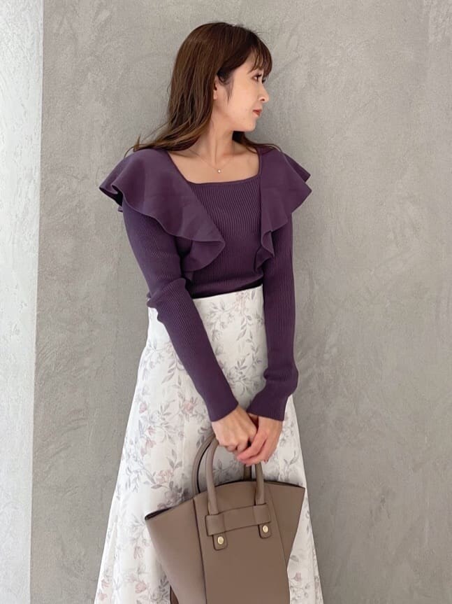 ピンク系のスカート、ブラウン系のハンドバッグ、パープル系のニット/セーターを着用したレディースの秋コーディネートの4枚目の写真