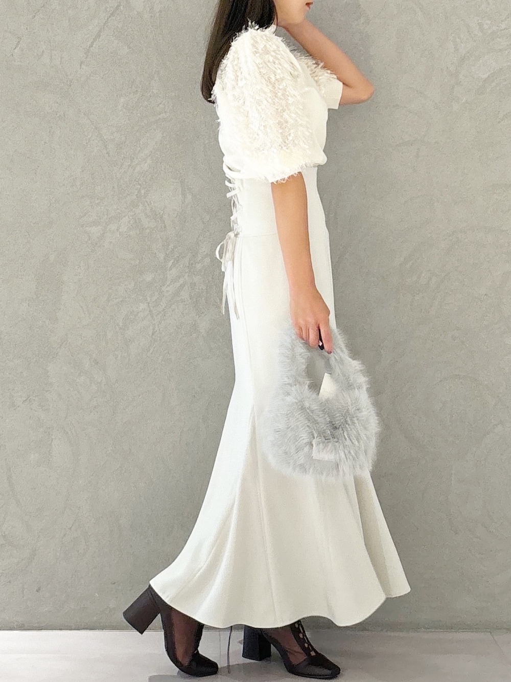 ブラウン系のブーツ、グレー系のハンドバッグ、ホワイト系のスカートを着用したレディースの夏コーディネートの4枚目の写真