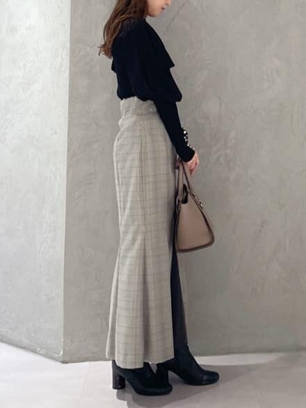 ブラウン系のハンドバッグ、グレー系のスカート、ブラック系のニット/セーターを着用したレディースの秋コーディネートの7枚目の写真