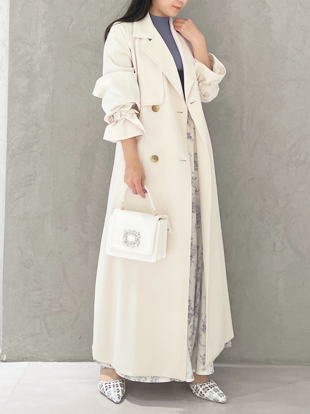 シルバー系のパンプス、ホワイト系のショルダーバッグ、ブルー系のニット/セーターを着用したレディースの春コーディネートの2枚目の写真