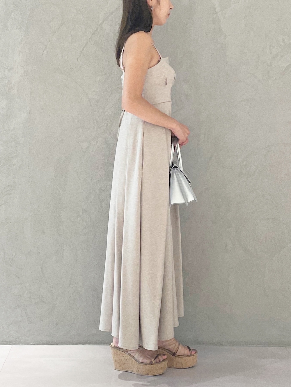 ベージュ系のワンピース、シルバー系のショルダーバッグ、ブラウン系のサンダルを着用したレディースの夏コーディネートの3枚目の写真