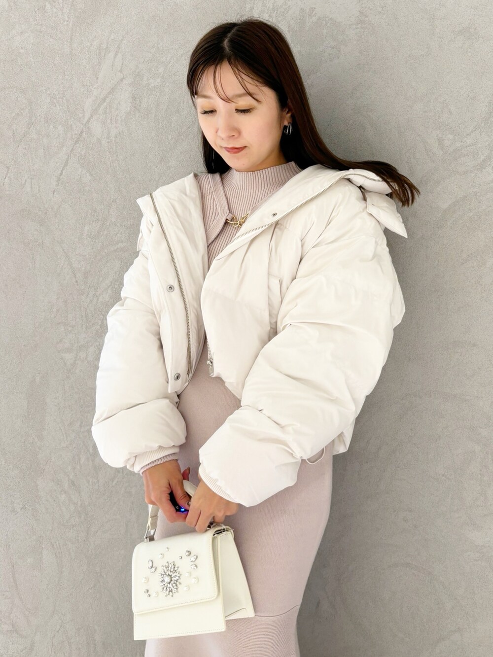 ピンク系のワンピース、ブラック系のブーツ、ホワイト系のショルダーバッグを着用したレディースの秋コーディネートの2枚目の写真